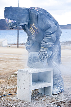 Local Inuit boy, carving from granite a polar bear. Cape Dorset, Baffin Island, Qikiqtaaluk, Nunavut, Canada, North America