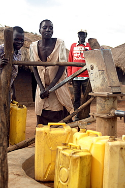 An IDP camp (internally displaced people) in Te-Tugu district of Northern Uganda has been created to accommodate the mass of Ugandan refugees fleeing the LRA (Lords Resistance Army) who are fighting the Ugandan government and its people.  Here, women are filling up water from a deep water well. Te-Tugu, Uganda, East Africa