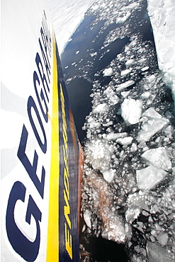 The National Geographic Endeavour breaking through new fast ice around the Antarctic Peninsula. Note the orange hull paint left on the ice where the bow has pushed through.