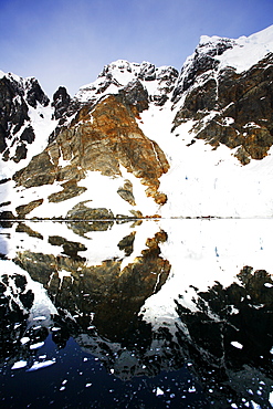 Reflections and snow covered mountains in Lemaire Channel in Antarctica.