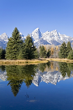 Reflected light on water from the Grand Teton Mountain Range, outside of Jackson Hole, Wyoming. This image was shot from the Schabawacker Landing on the snake river.