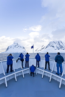 The Lindblad Expedition ship National Geographic Explorer transits Lemaire Channel in late evening light on the west side of the Antarctic peninsula in Antarctica