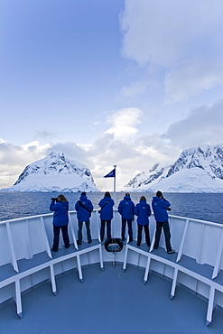 The Lindblad Expedition ship National Geographic Explorer transits Lemaire Channel in late evening light on the west side of the Antarctic peninsula in Antarctica