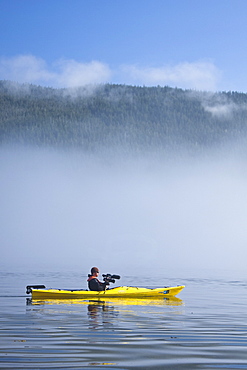 Kayaking from the Lindblad Expedition ship National Geographic Sea Lion in the fog in Tracy Arm in Southeast Alaska, USA. Pacific Ocean. No model or property release available for this photograph.