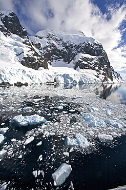 The Lindblad Expedition ship National Geographic Explorer transits Lemaire Channel in late evening light on the west side of the Antarctic peninsula in Antarctica