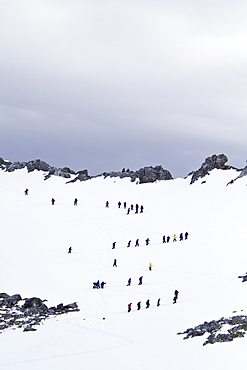 Guests from the Lindblad Expedition ship National Geographic Explorer climb steep snow trail at Orne Harbor, Antarctica