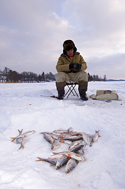 Ice fisherman on frozen Lake Puhajarv, Otepaa, Valgamaa, Estonia