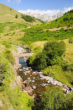 Bridge over Rio Aragon Subordan in the upper Hecho valley overlooked by  karst limestone peaks and woods, Huesca, Aragon, Spain, Europe